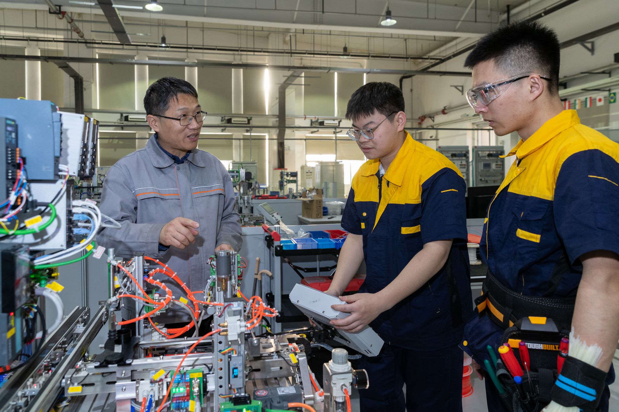 2023年7月,“师傅”钟平(左一)向“徒弟的徒弟” 传授工业 4.0 项目技术要领。 2023年7月,“师傅”钟平(左一)向“徒弟的徒弟” 传授工业 4.0 项目技术要领。